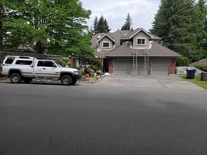 Brick and shingle home with fresh paint on the garage and upper story