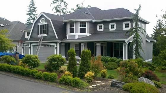 Close view of freshly painted gray siding with crisp white window trim