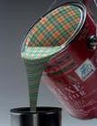A paint can pouring paint with tartan plaid swirled through it